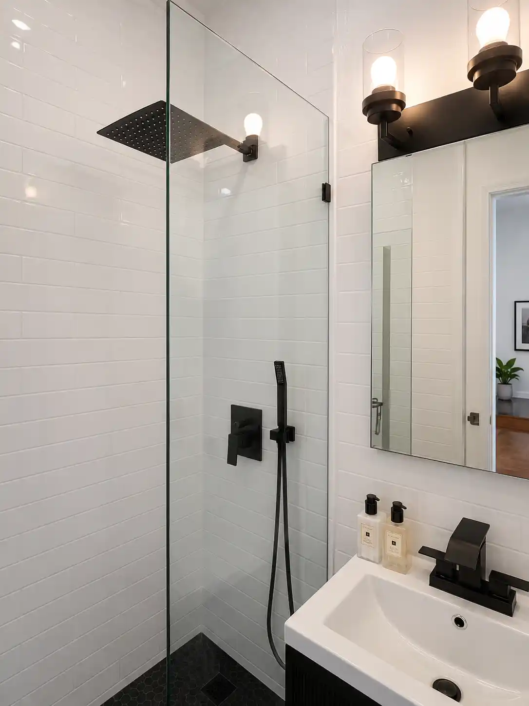 Completed bathroom renovation featuring frameless shower & matte black details