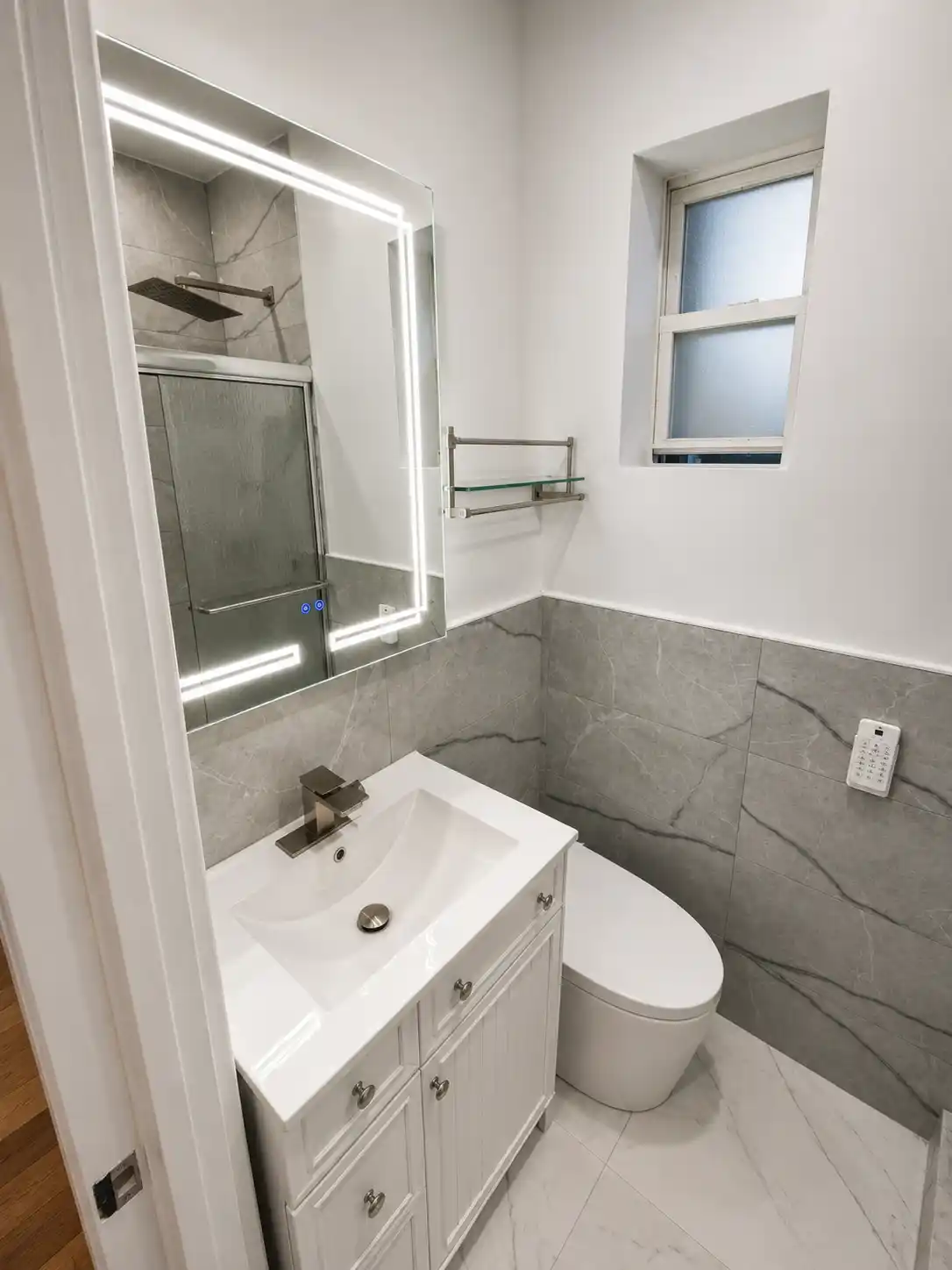 Completed bathroom renovation featuring compact gray marble bathroom
